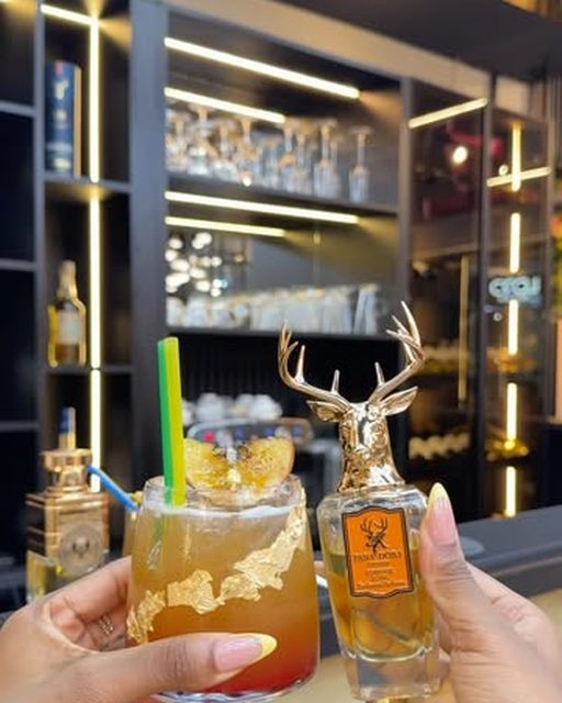 A SEN Bar cocktail beside the Pana Dora stag bottle that inspired it