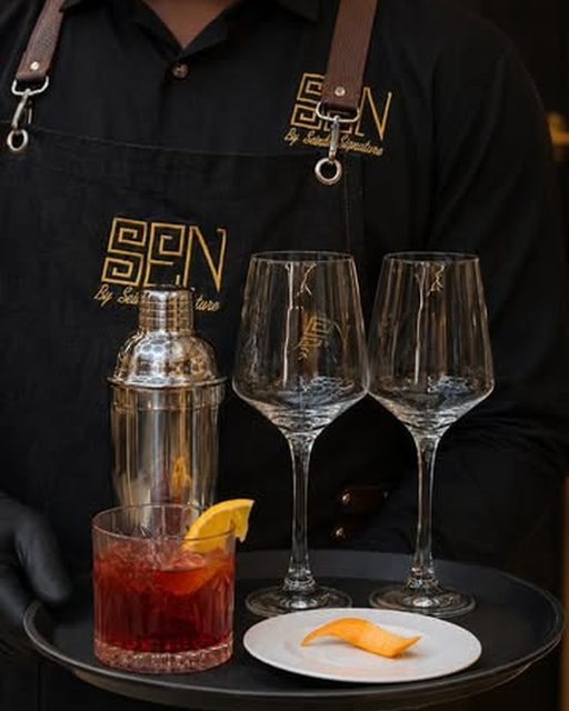 A SEN Bar bartender serving a signature cocktail